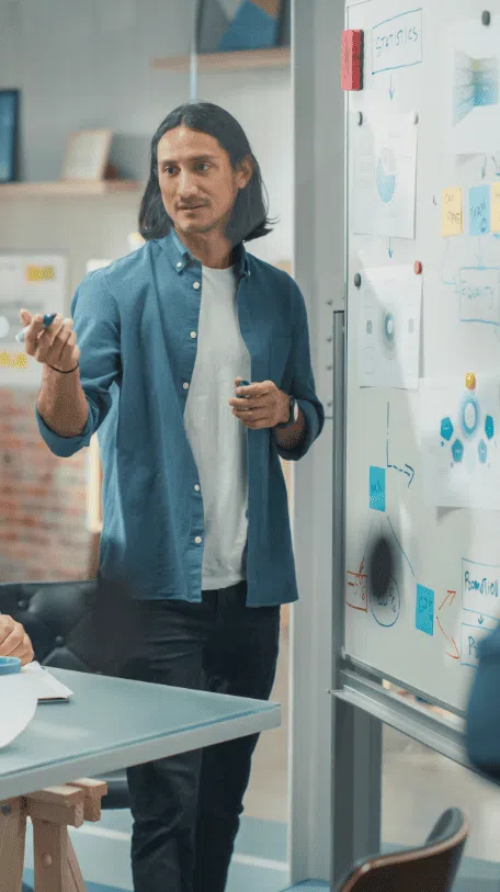 Man presenting information from graphs on whiteboard