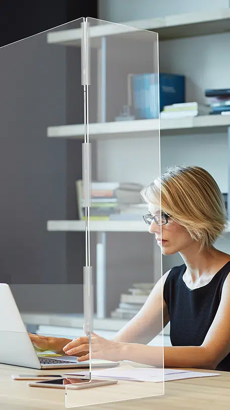 Shoppop Case Study, Woman in office at desk behind cough shield