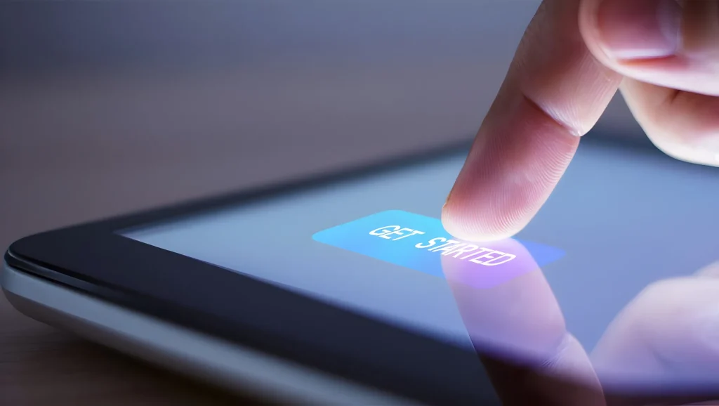 A finger taps a Get Started call-to-action button on a touchscreen.